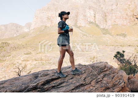 Woman in hiking attire standing outdoors 90391419