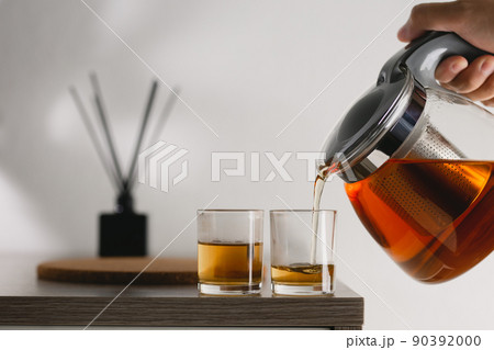 Hot tea being poured into glass tea cup. 90392000