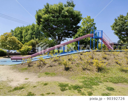 公園にピンク色の滑台がある。 背景は青空がとても綺麗だ。 公園にピンク色の滑台がある。 背景は青空がとても綺麗だ。 90392726