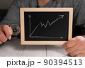 A woman holding a gold bitcoin and a board with a graph. Cryptocurrency. 90394513