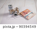Close-up of a stack of hundred-dollar bills and five thousand rubles on a table. 90394549