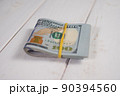 Close-up of a stack of hundred-dollar bills on a light background 90394560