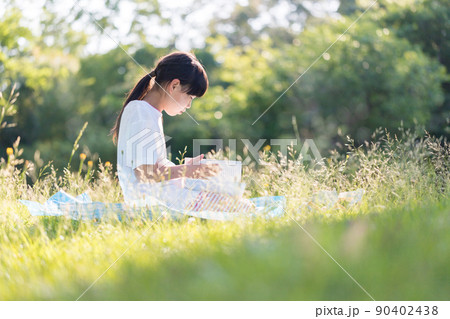 夏の公園で読書している小学生の女の子の姿 夏の公園で読書している小学生の女の子の姿 90402438