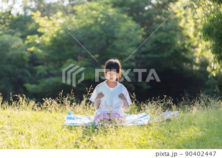 夏の公園で読書している小学生の女の子の姿 夏の公園で読書している小学生の女の子の姿 90402447