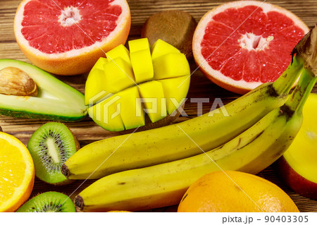 Assortment of tropical fruits on wooden table. Still life with bananas, mango, oranges, avocado, grapefruit and kiwi fruits Assortment of tropical fruits on wooden table. Still life with bananas, mango, oranges, avocado, grapefruit and kiwi fruits 90403305