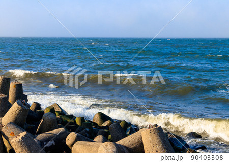 Storm in the Baltic sea. Storm waves crashing on the breakwater in Darlowo, Poland 90403308