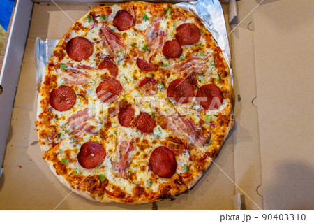 Delicious fresh pizza in cardboard box. Concept for home delivery of food, fast food, delivery of pizza Delicious fresh pizza in cardboard box. Concept for home delivery of food, fast food, delivery of pizza 90403310
