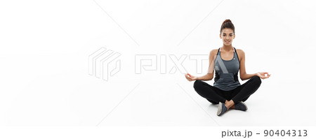Healthy and Fitness concept - Beautiful American African lady in fitness clothing doing yoga and meditation. Isolated on white background. Healthy and Fitness concept - Beautiful American African lady in fitness clothing doing yoga and meditation. Isolated on white background. 90404313