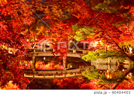 真っ赤に染まる紅葉の夜景風景とライトアップされた橋のリフレクション 90404403