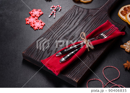Christmas table setting with empty black ceramic plate, fir tree and black accessories 90406835