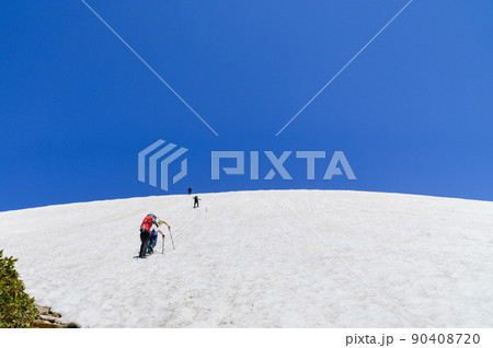 快晴の空と雪渓を登る登山者（谷川岳） 90408720