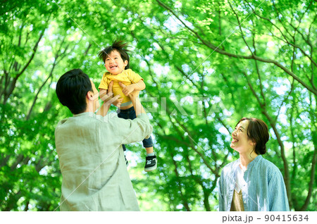 新緑の中触れ合う家族 90415634