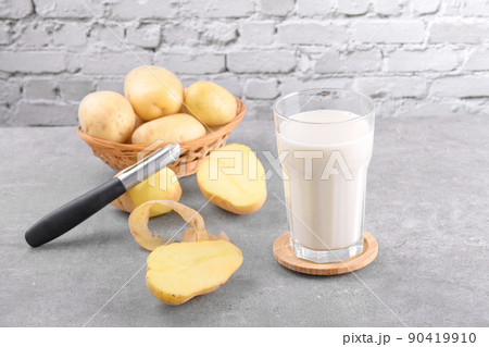 Vegan potato milk and potato on grey stone table background. Plant based alternative milk replacer and lactose free 90419910