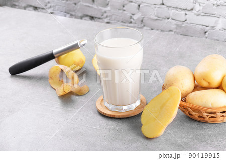 Vegan potato milk and potato on grey stone table background. Plant based alternative milk replacer and lactose free 90419915