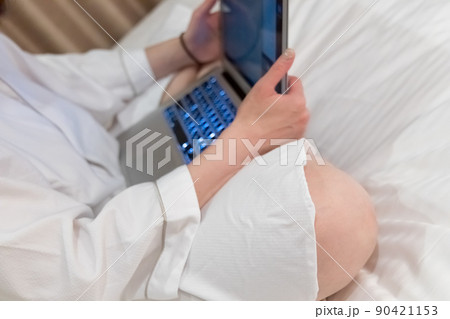 ベッドでパソコンを使用している女性 リモートワーク 出張 ワーケーション イメージ ベッドでパソコンを使用している女性 リモートワーク 出張 ワーケーション イメージ 90421153