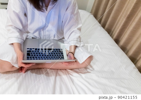 ベッドでパソコンを使用している女性 リモートワーク 出張 ワーケーション イメージ ベッドでパソコンを使用している女性 リモートワーク 出張 ワーケーション イメージ 90421155