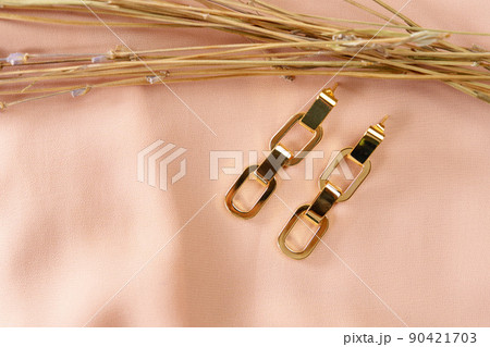 Gold earrings close-up decoration. Luxury female jewelry. 90421703
