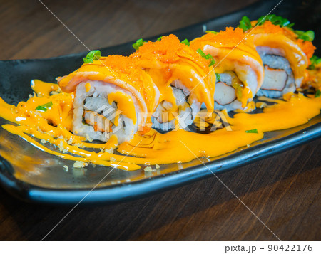 Salmon grilled on a maki roll topped with spicy cheese sauce on plate Salmon grilled on a maki roll topped with spicy cheese sauce on plate 90422176