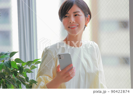 スマホを持ち微笑む女性1 90422874