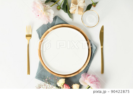 Beautiful table setting with golden cutlery and peony flowers, mock up 90422875