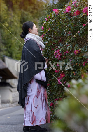 道端の寒椿と着物の女性 90425272
