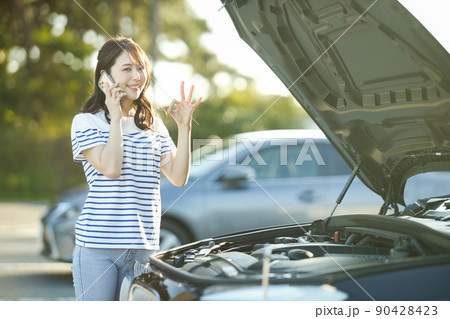 車の故障で電話をする若い女性 90428423
