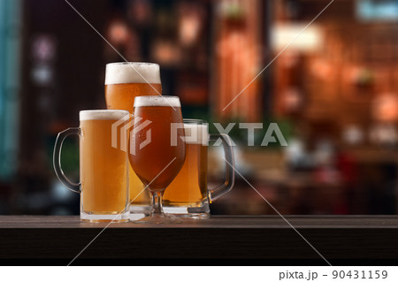 Four different glasses of beer on counter in pub. Four different glasses of beer on counter in pub. 90431159