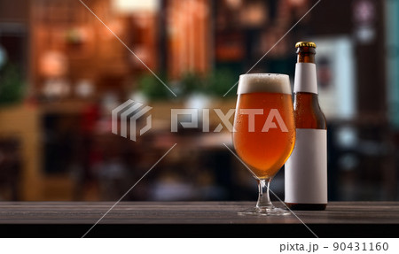 Bottle and glass of beer on counter in pub. Bottle and glass of beer on counter in pub. 90431160