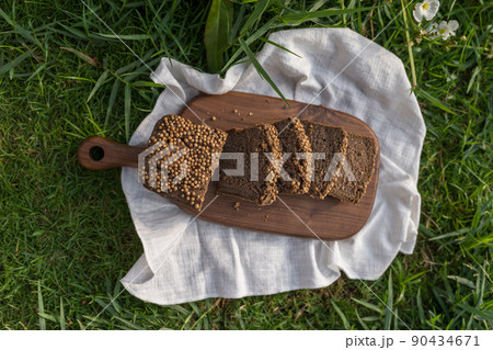 Composition of homemade custard bread on wood board with white cloth napkin on the green grass. High quality photo 90434671