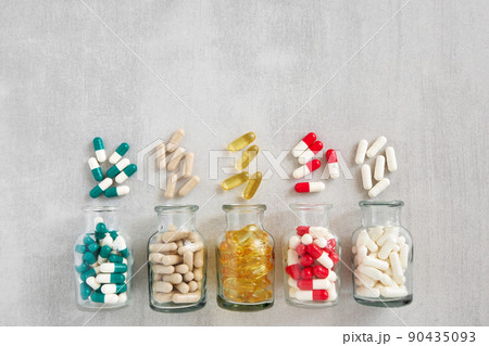 Five glass bottles of supplements pills. Variety of nutritional supplements and vitamin capsules. Top view. Flat lay. 90435093