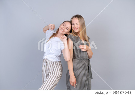 Mother and daughter are hugging and having fun together on background in studio 90437043