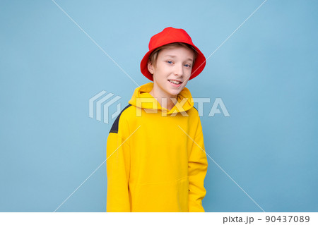 Portrait surprised young guy in yellow sweater and red panama hat on a blue Portrait surprised young guy in yellow sweater and red panama hat on a blue 90437089