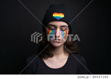 Crying eyes with rainbow iris flag on colored face concept sadness and pain Crying eyes with rainbow iris flag on colored face concept sadness and pain 90437104
