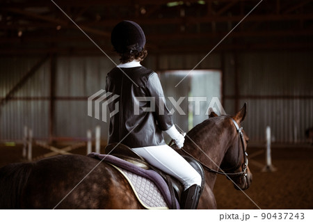 Young woman is engaged in equestrian sports 90437243