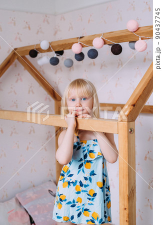 Little cute girl child blonde at home in her wooden bed house Little cute girl child blonde at home in her wooden bed house 90437745