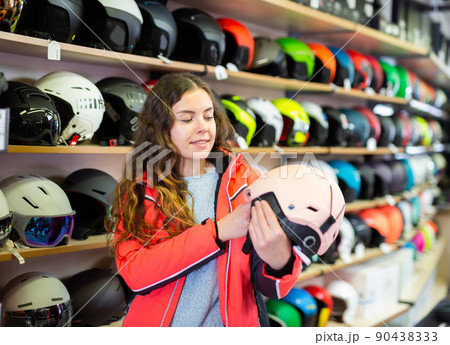 woman choosing helmet in a sports equipment store woman choosing helmet in a sports equipment store 90438333