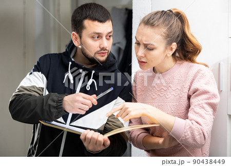 Man asking frustrated confused woman sign papers 90438449