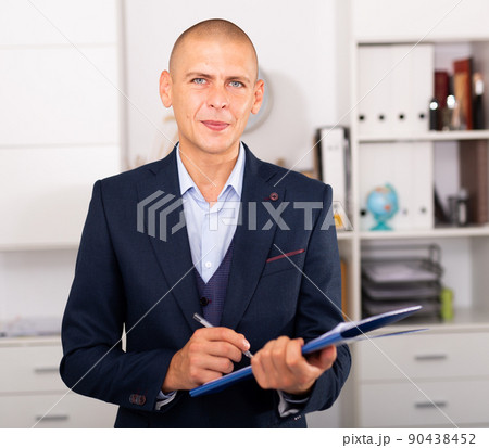 Portrait of positive business man with folder of documents Portrait of positive business man with folder of documents 90438452