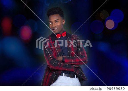 young man at dance club crossed arms checkered jacket and bow tie on blue bokeh lights circle spot and smoke background young man at dance club crossed arms checkered jacket and bow tie on blue bokeh lights circle spot and smoke background 90439080