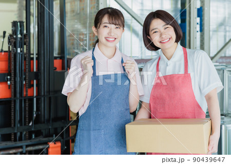 倉庫で明るく働く女性スタッフ 倉庫で明るく働く女性スタッフ 90439647