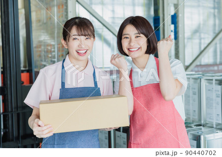倉庫で明るく働く女性スタッフ 倉庫で明るく働く女性スタッフ 90440702