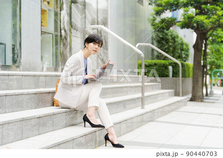 階段でパソコンを操作する女性 90440703