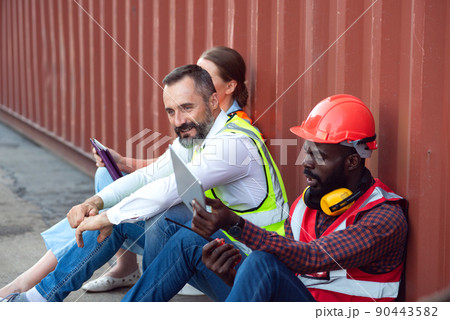 Two manager and one engineer sit and discuss about their job for shipment to customer. Distribution storage commerce port cargo. 90443582