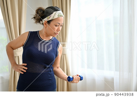 Sporty and active Asian aged woman training workout exercise at home Sporty and active Asian aged woman training workout exercise at home 90443938