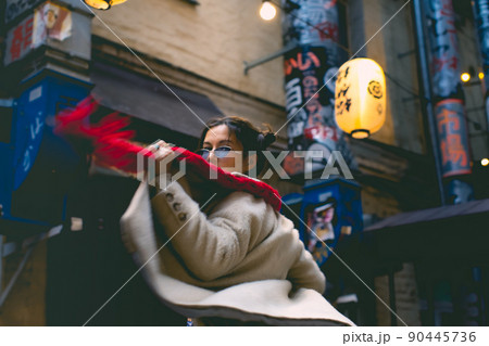 Portrait of an attractive woman with a scarf. A walk through the city in a Japanese neighborhood. Front view. Portrait of an attractive woman with a scarf. A walk through the city in a Japanese neighborhood. Front view. 90445736