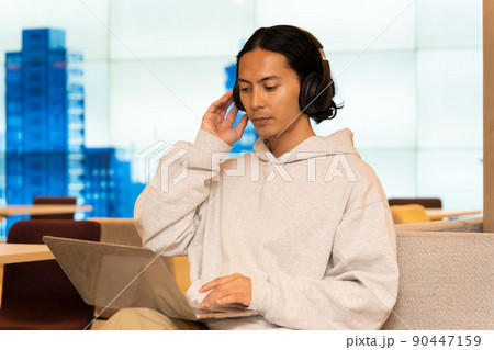 ヘッドホンを付けている若い男性 90447159