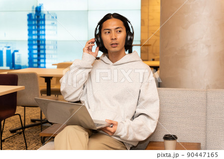 ヘッドホンを付けている若い男性 90447165