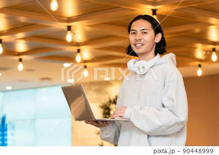 ノートパソコンを持つヘッドフォンの男性 ノートパソコンを持つヘッドフォンの男性 90448999