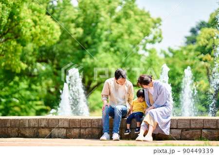 噴水のある公園で遊ぶ家族 90449339
