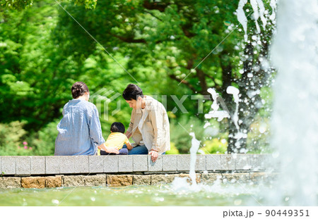 噴水のある公園で遊ぶ家族 90449351